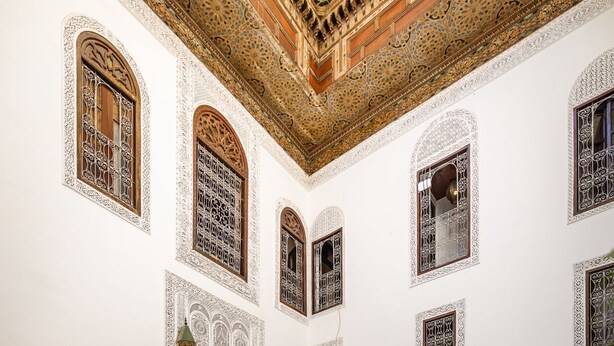 A spacious courtyard with intricate tile work, a central fountain, and seating areas. - Riad Tizwa Fes (Fes)