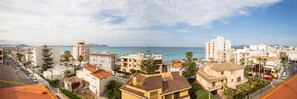 A coastal residential area with buildings, a clear sky, and the sea in the background. - Hotel Villa Barbara (Santa Margalida)