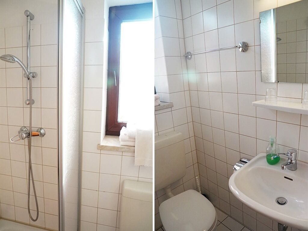 A bathroom with a shower, toilet, and sink.