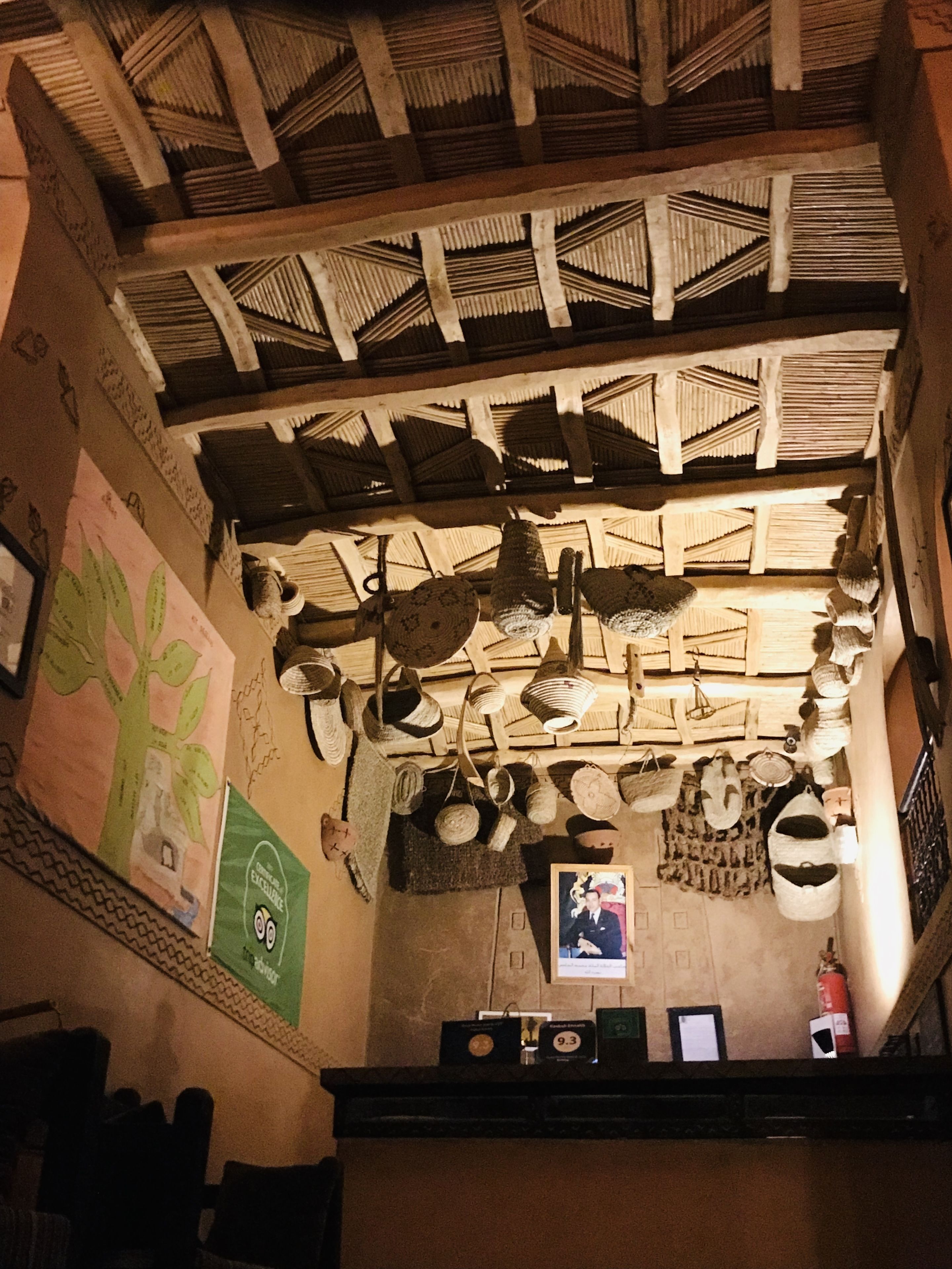 A room with a high ceiling, wooden beams, and various hanging items like baskets and bags.