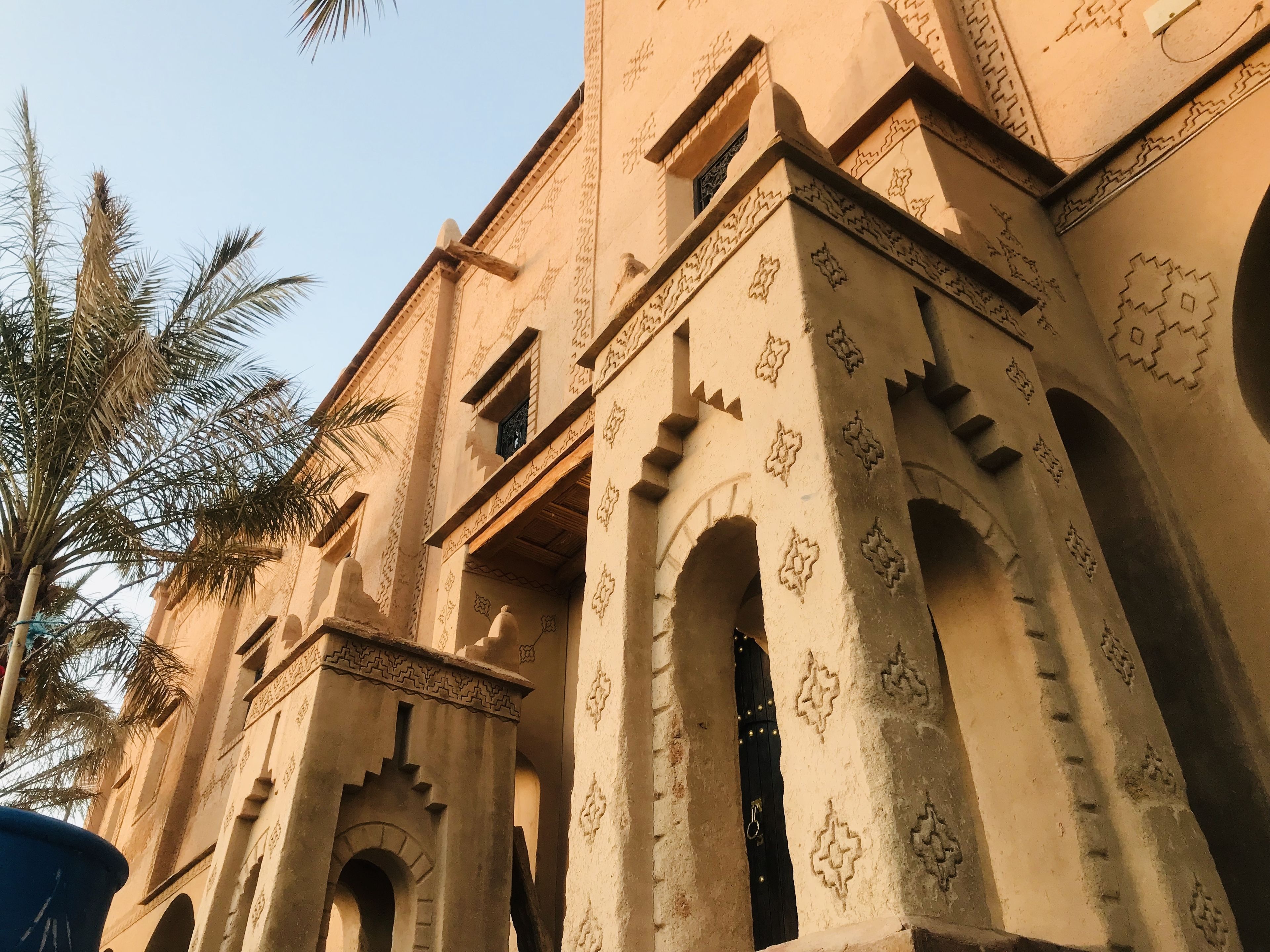 A building with arched doorways and intricate carvings on the walls.