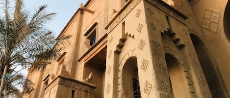 A building with arched doorways and intricate carvings on the walls.