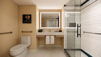 A modern bathroom with a toilet, sink, and glass shower stall.