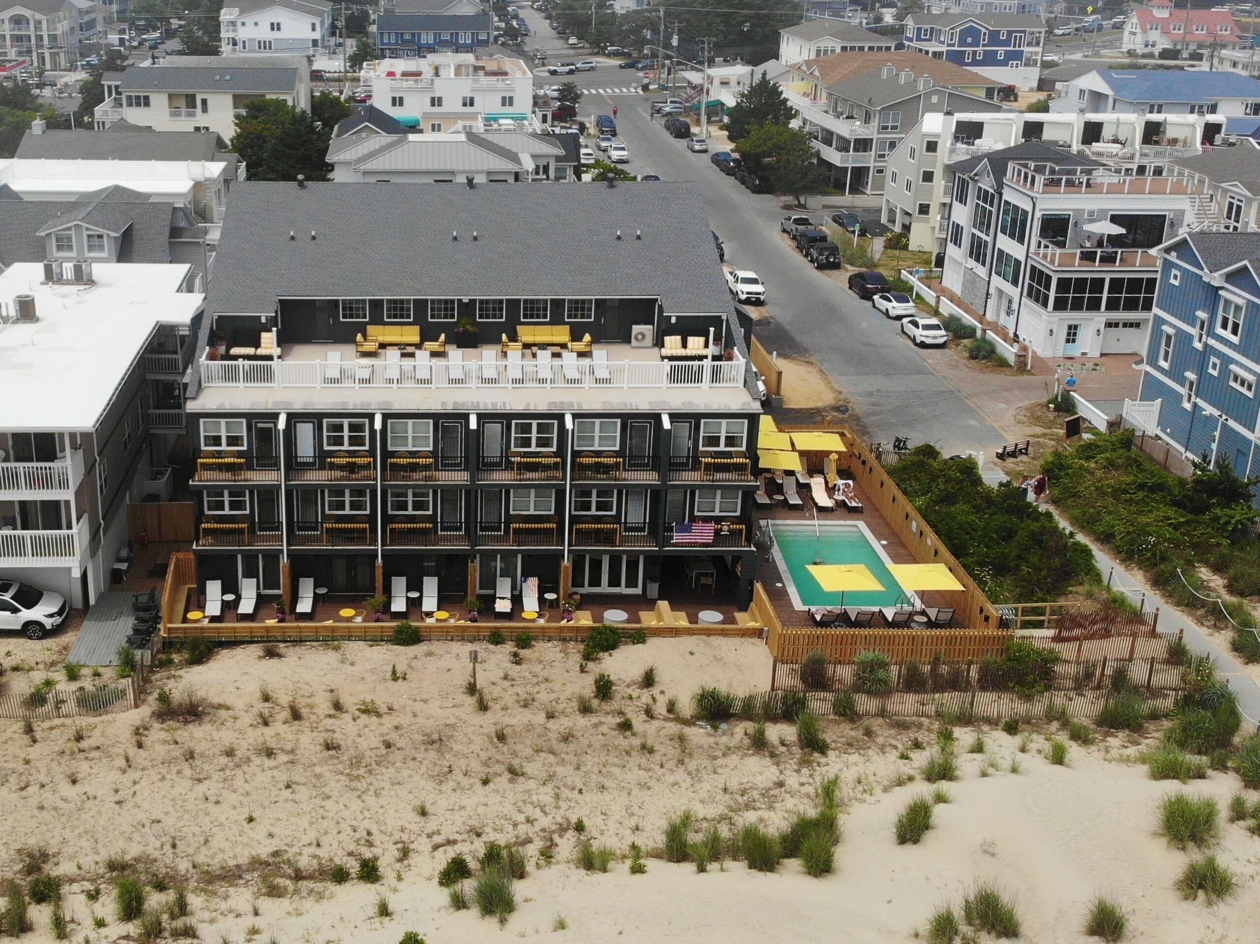 A multi-story hotel with a rooftop pool and outdoor seating area.