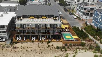 A multi-story hotel with a rooftop pool and outdoor seating area.