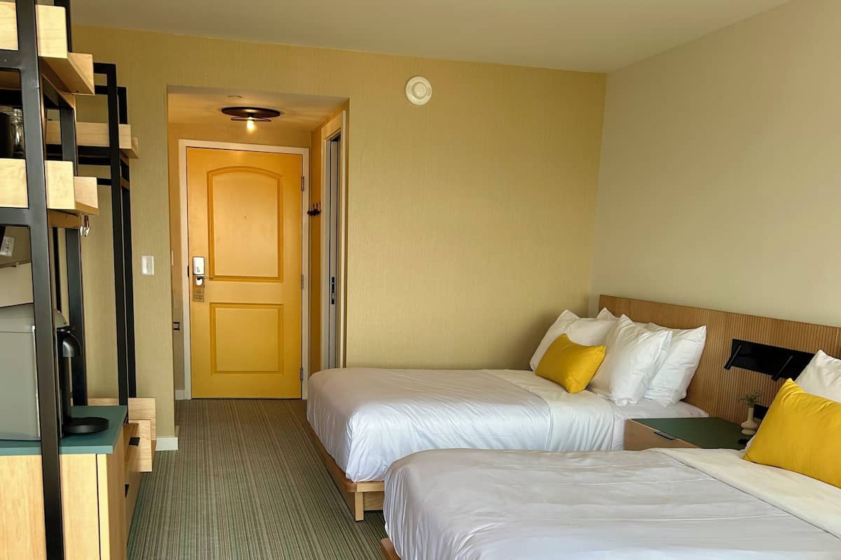 Una habitación de hotel con dos camas, un escritorio y una silla.