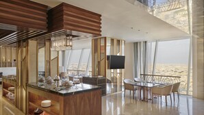 Un intérieur moderne avec un îlot central, un coin repas et une grande fenêtre donnant sur la ville.