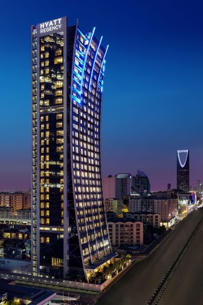 Un hôtel moderne doté d’une façade incurvée originale, de plusieurs étages et de fenêtres illuminées.