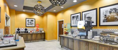 A modern coffee shop with a counter, coffee machines, and decorative lighting.