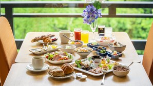 A breakfast table with various dishes, drinks, and a vase of flowers. - Select Grand Kagayamanaka (Kaga)