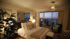Ruime hotelkamer met een groot bed, een zithoek, stadszicht en een balkon.