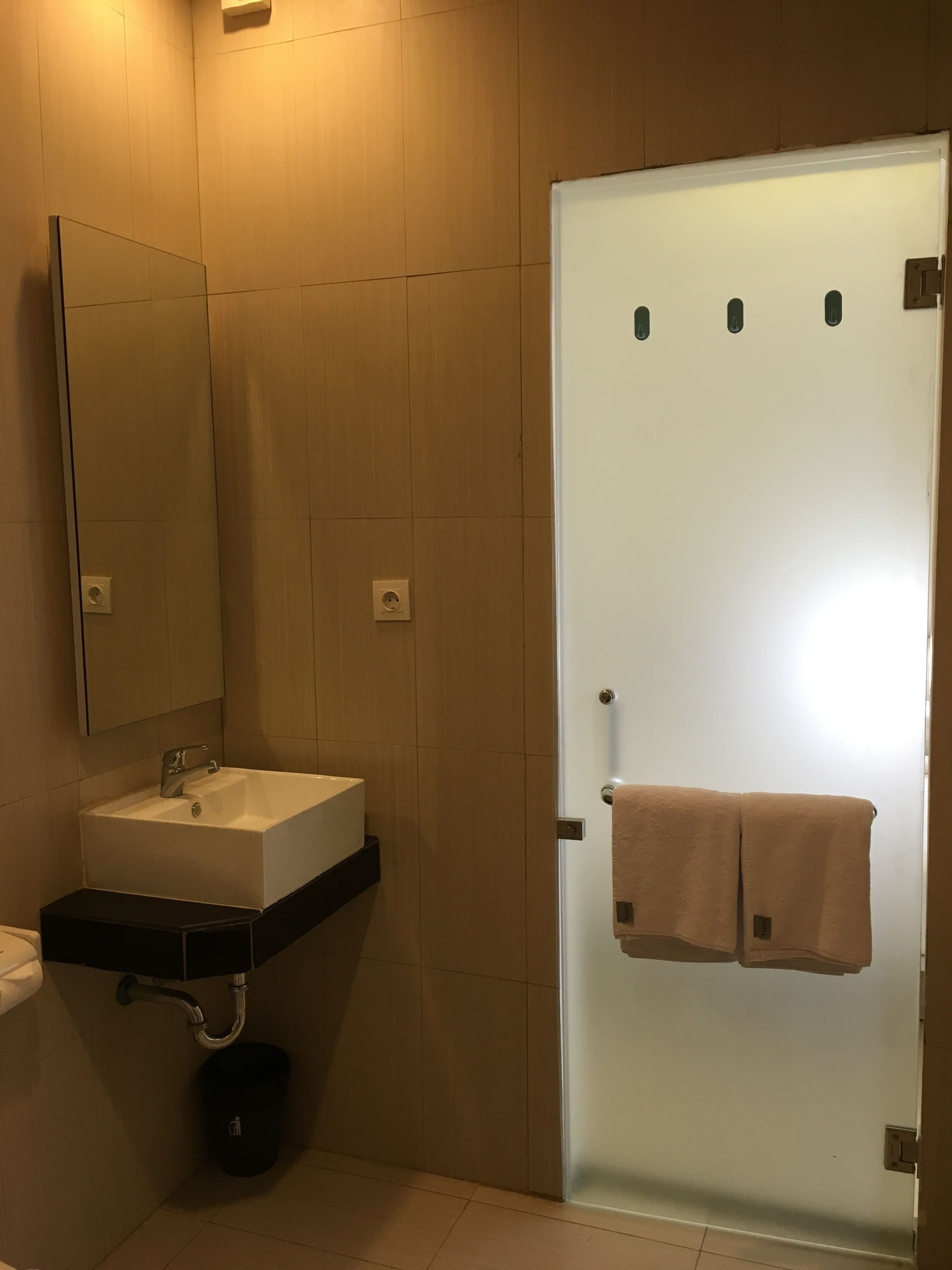 A bathroom with a white sink, a mirror, and a towel rack.