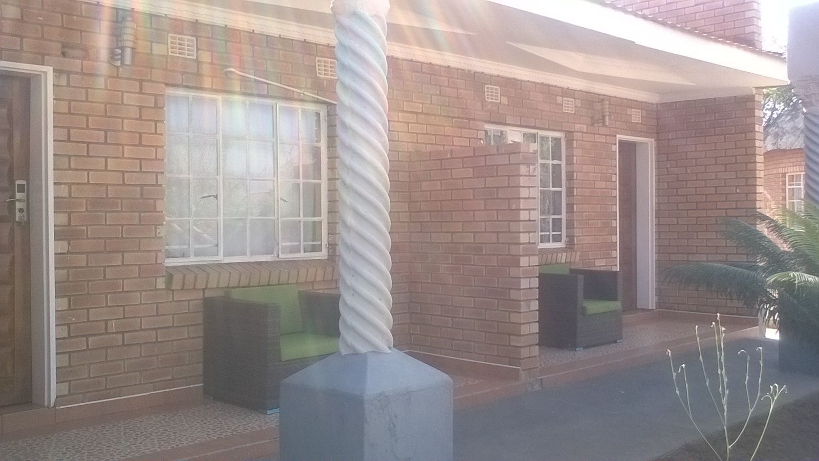A building with brick walls, large windows, and outdoor seating areas.