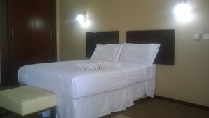A neatly made bed with white linens in a hotel room. - Sahara Stones Hotel (Palapye)