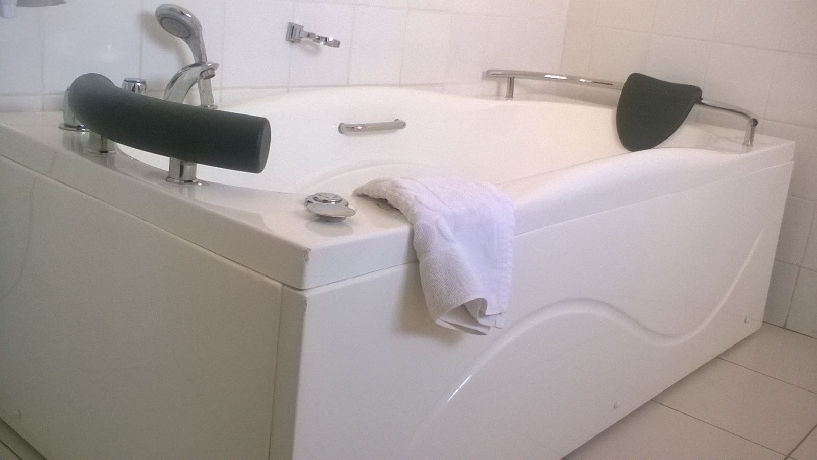 Un baño moderno con bañera, dos lavamanos y un perchero para toallas.