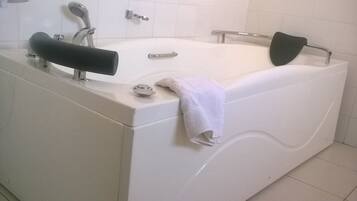 Un baño moderno con bañera, dos lavamanos y un perchero para toallas.