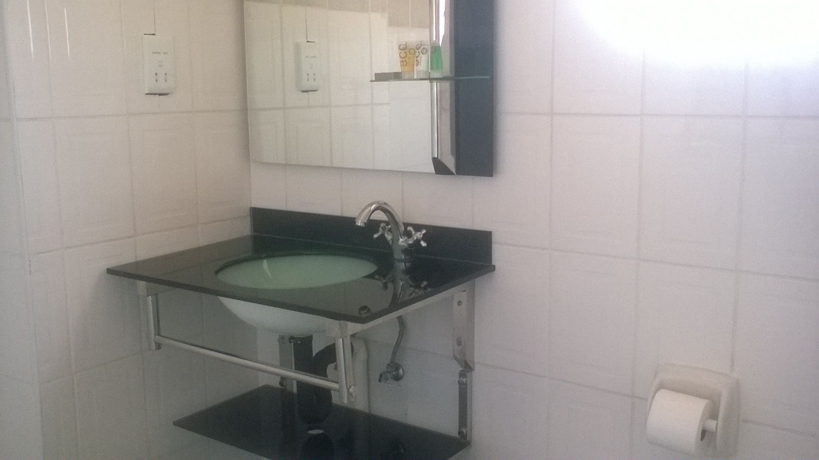 Une salle de bain avec un lavabo noir, un miroir et des toilettes.