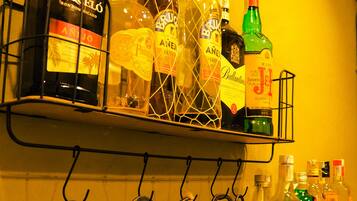 Una estantería con varias botellas de licor y un juego de abridores.
