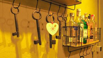Una repisa montada en la pared con varias botellas de licor y un adorno con forma de corazón.