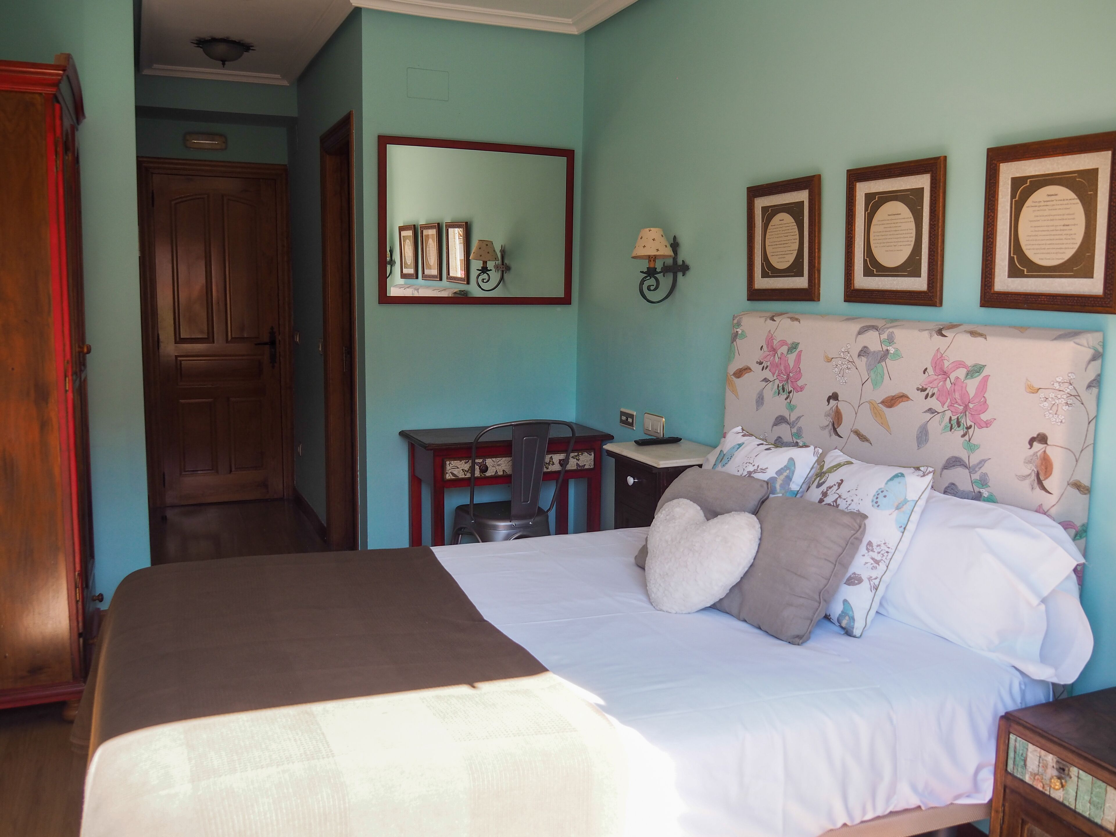 Un dormitorio con cama, escritorio, silla y armario.