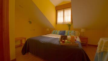 A bedroom with a bed, bedside tables, a window with curtains, and a tray with apples and a drink on the bed.