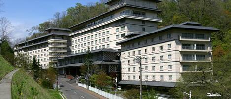 Hotel com vários andares e design arquitetônico moderno, com varandas e um átrio central.