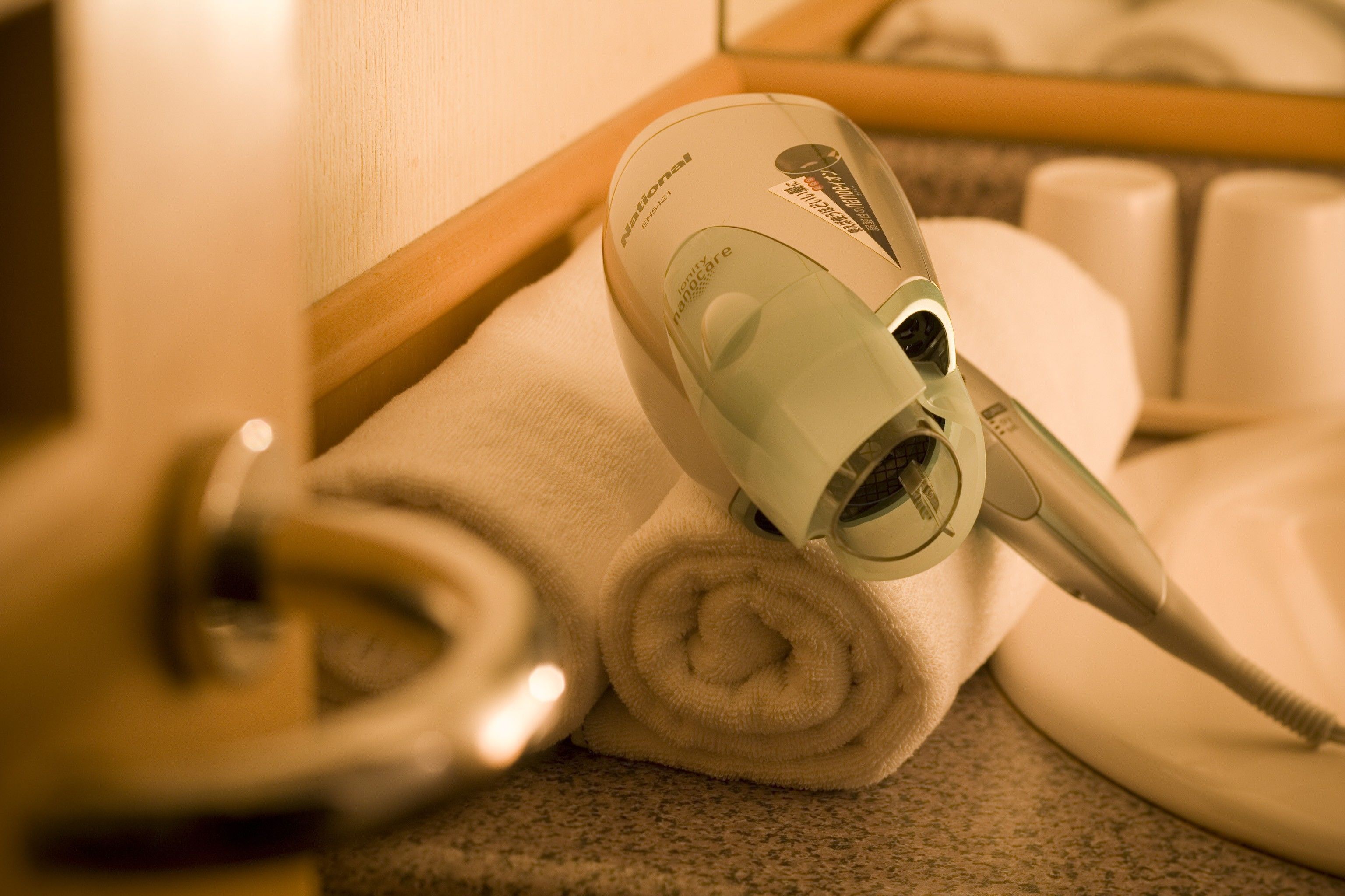 A hair dryer on a towel in a bathroom.