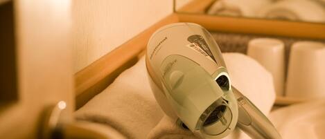 A hair dryer on a towel in a bathroom.