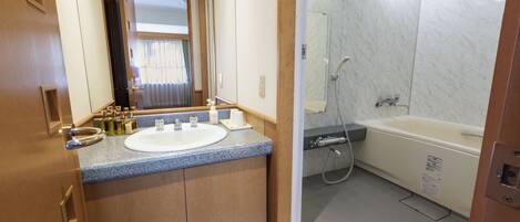 A bathroom with a sink, mirror, and shower.