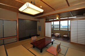 A traditional Japanese room with tatami flooring, a low wooden table, and sliding doors. - Kohannoyado Morimoto (Kaga)