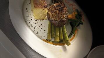 A plate with a piece of bread, a grilled item, and green vegetables.