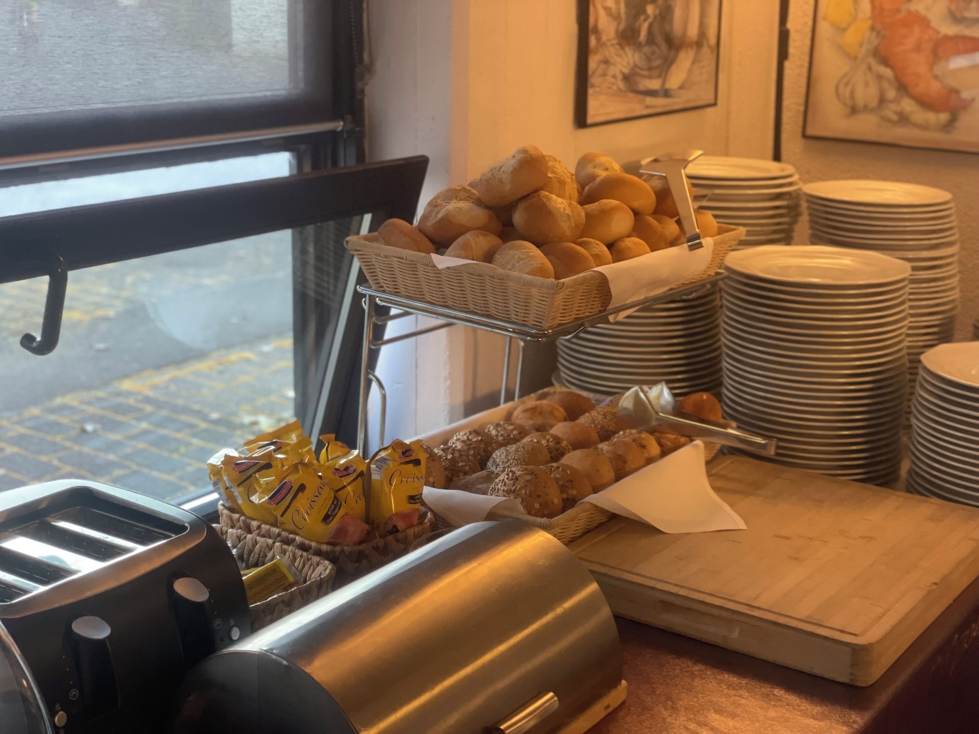 Un buffet avec des paniers à pain, des assiettes et un grille-pain.