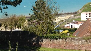 A coastal view with a clear sky, a sandy beach, and a few buildings in the distance. - Auberge du vieux puits (Dieppe)