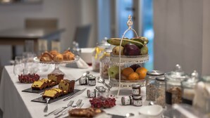 Ein Buffet mit verschiedenen Speisen, darunter Gebäck, Früchte und Soßen.