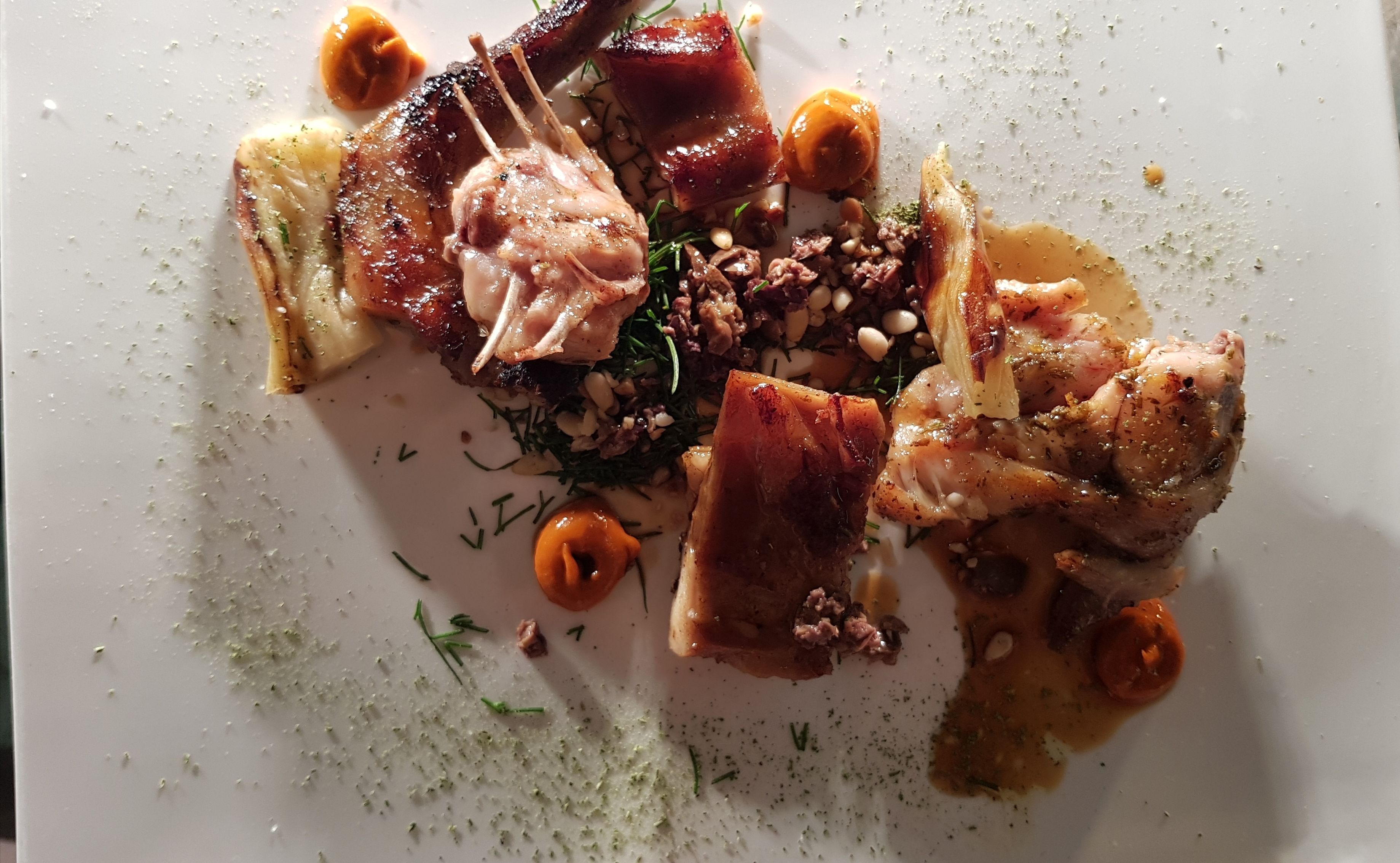 A plate of food with various meats and vegetables.