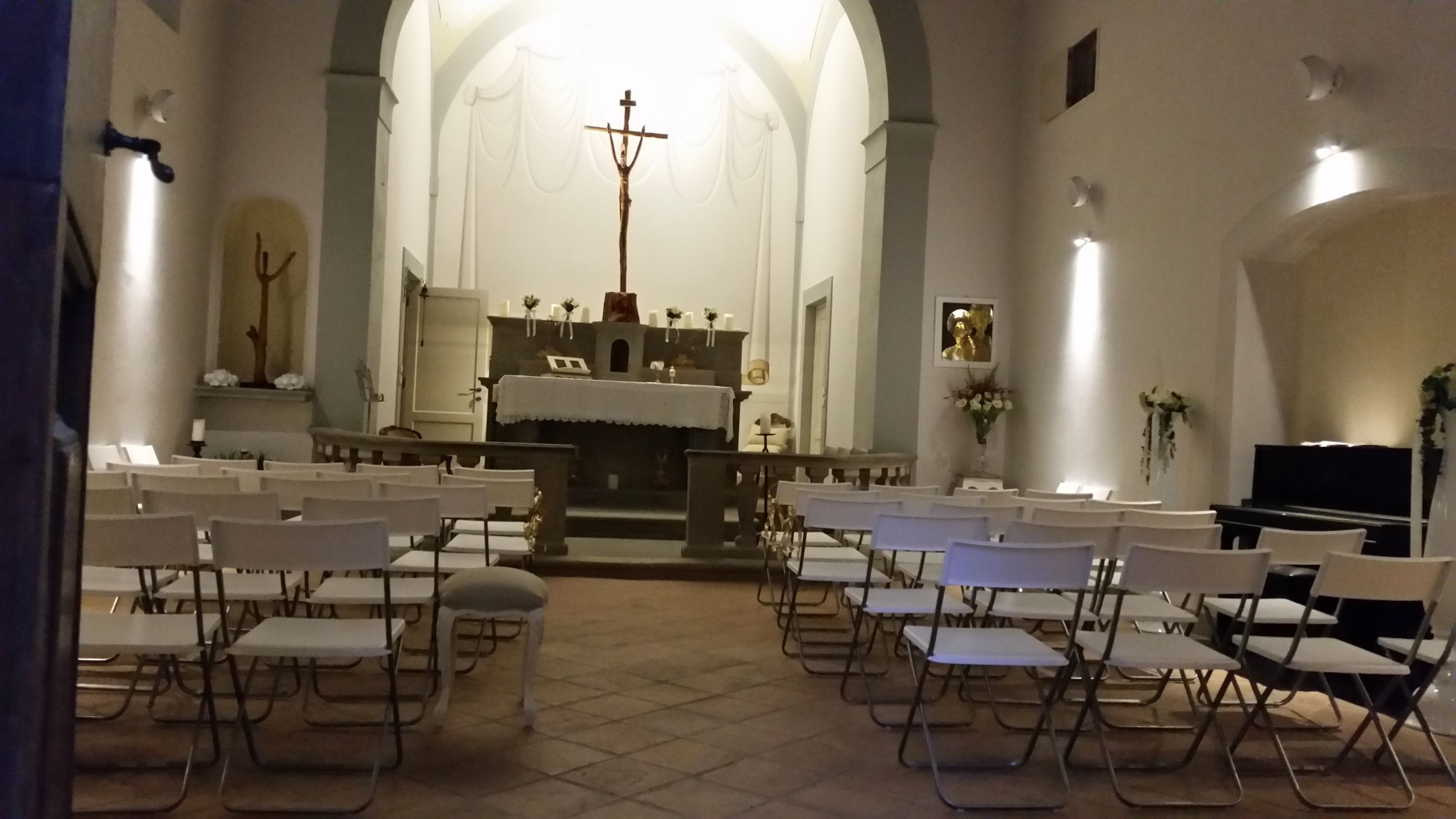 L’intérieur d’une église, avec des bancs disposés en rangées, un piano et un crucifix sur l’autel.