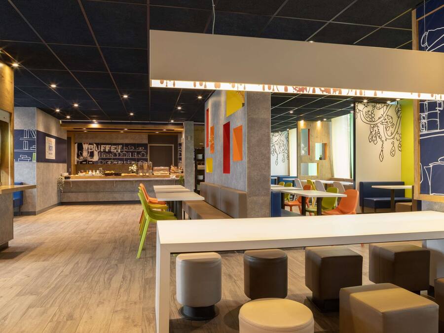 Decoração moderna com balcão central, áreas de estar e arte vibrante nas paredes.