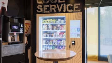 Ein Automaten mit der Aufschrift 'COOL SERVICE' bietet verschiedene Snacks und Getränke.