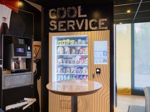 Un distributeur automatique portant l’inscription « SERVICE RAPIDE » et proposant une variété de collations et de boissons.