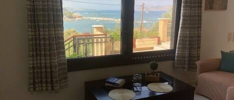 Una habitación con vista al mar, una mesita con una planta y un sofá.