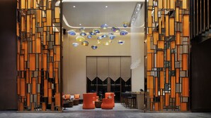 A modern lobby with a geometric wall design, seating area, and hanging glass chandeliers. - Novotel Nanchang Sunac (Nanchang)