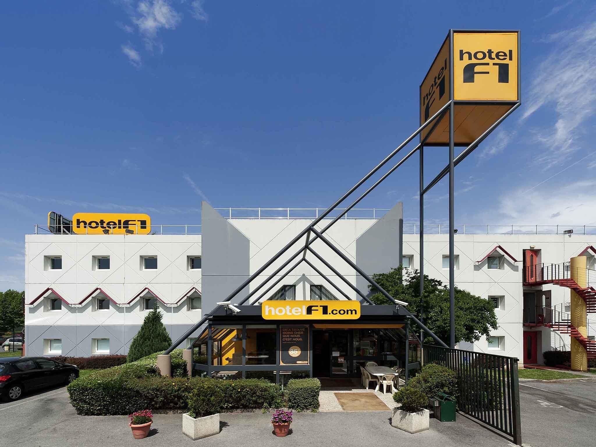 Un hotel de diseño moderno, con un llamativo letrero amarillo que dice 'hotel F1' y una dirección web.