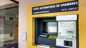 Una máquina automatizada para reservar habitaciones, con instrucciones y un terminal de pago.