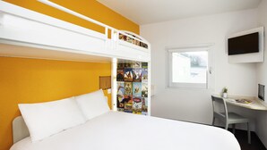 Una habitación con literas, un escritorio y una televisión.