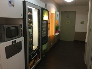 Guests can access a vending machine and microwave in this hotel hallway.