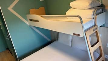 Un lit superposé avec une tête de lit, un oreiller et une échelle en bois.