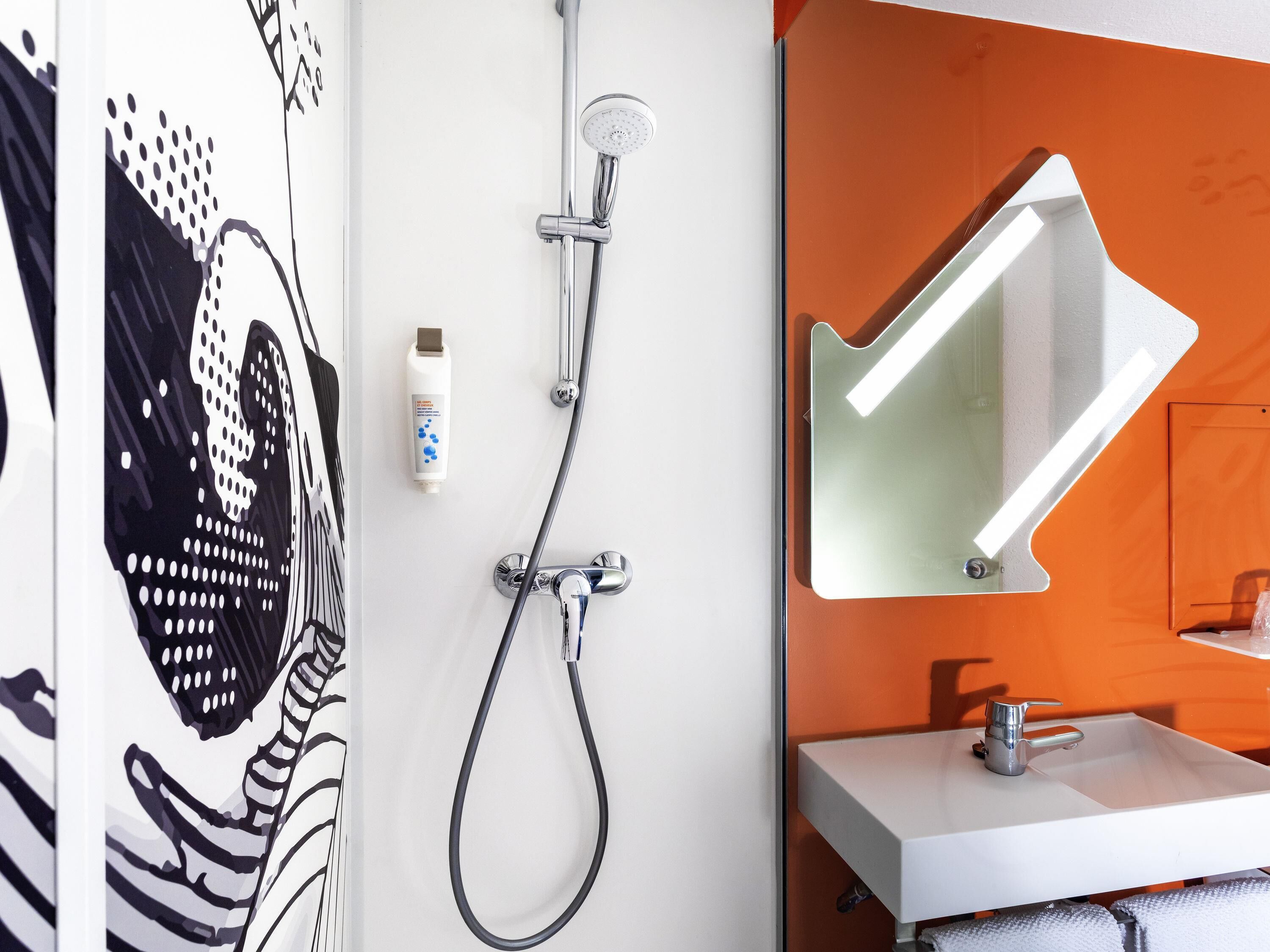 A bathroom with a shower, a sink, and a mirror.