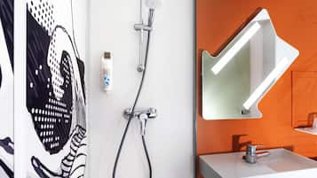 A bathroom with a shower, a sink, and a mirror.