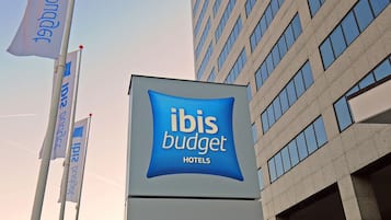 A sign for ibis budget hotels in Amsterdam City South with a welcoming message.