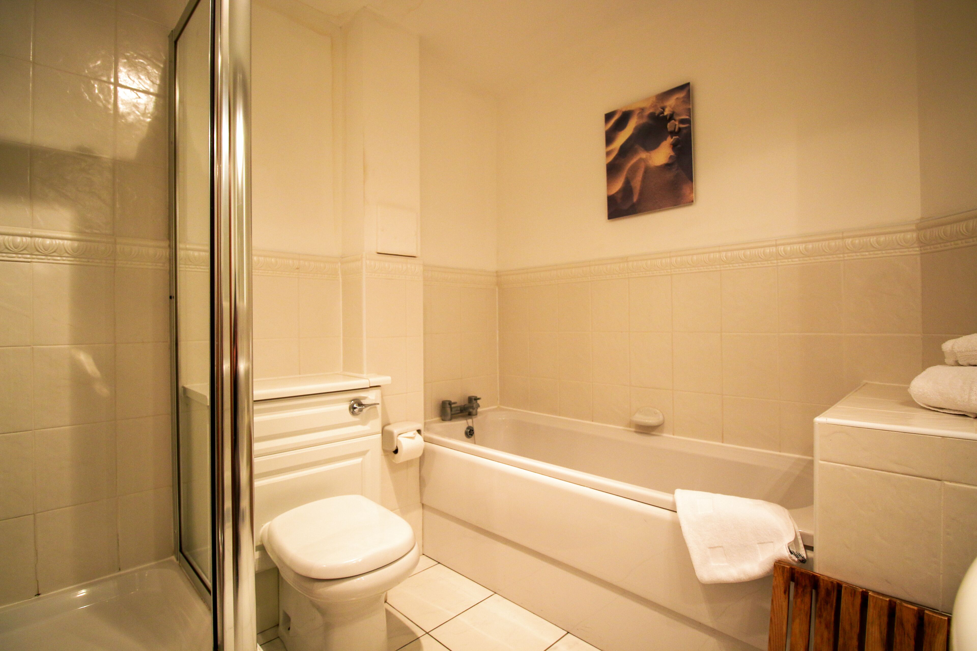 A bathroom with a toilet, bathtub, and shower.